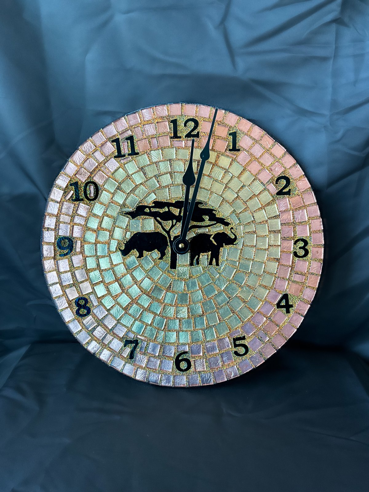 Handmade mosaic wall clock featuring two elephants beneath an acacia tree, in pastel mosaic tile with gold grout