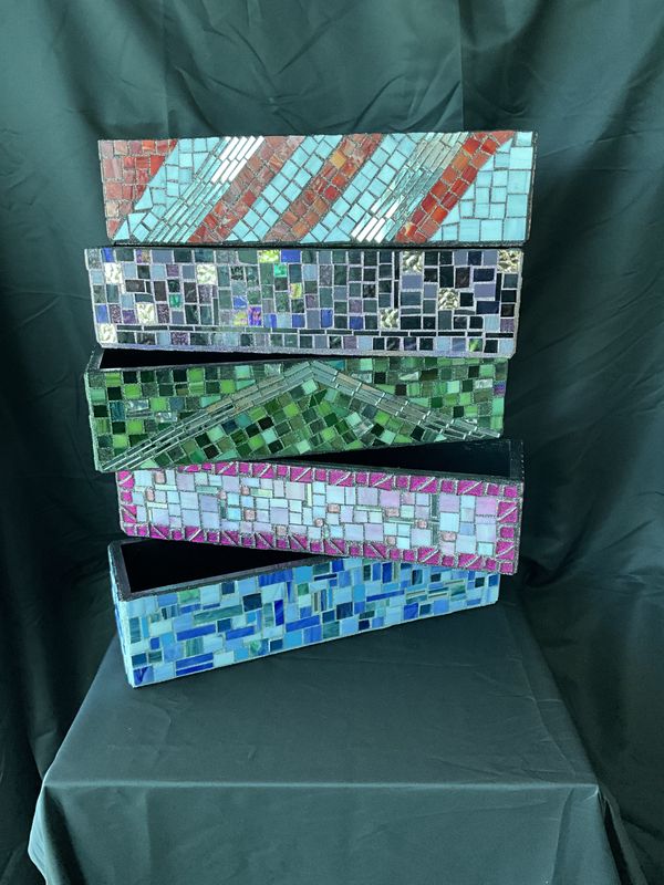 Stack of five rectangular mosaic boxes or trays in different color schemes including aqua, purple, green, pink, and blue