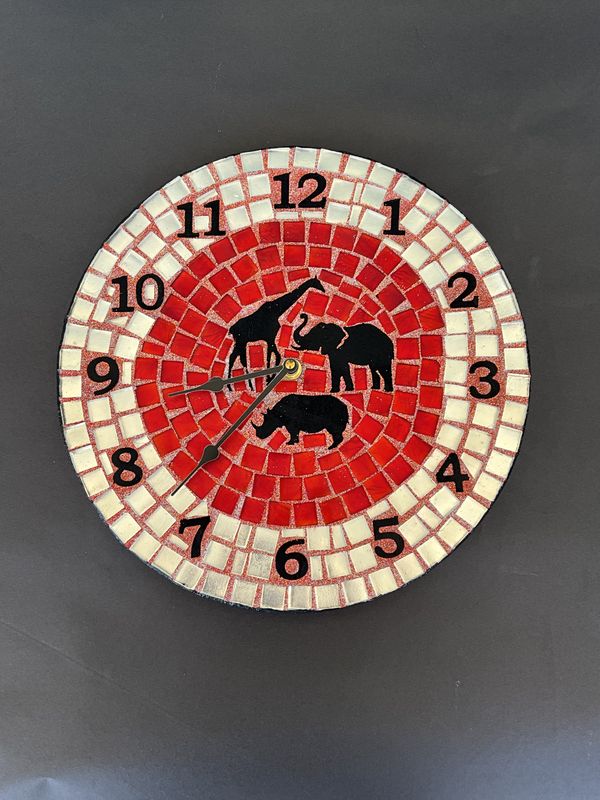 Round mosaic wall clock with elephant, giraffe, and rhino silhouettes on a red tile background with a cream outer ring